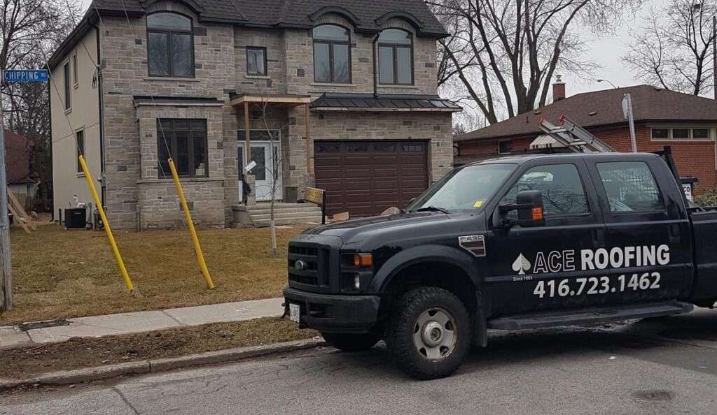 Roofing truck parked near house